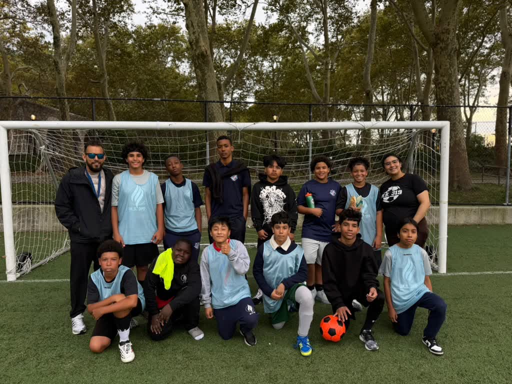 MSC Hawks players and coaches lined up in front of the goal, with a soccer ball in front
