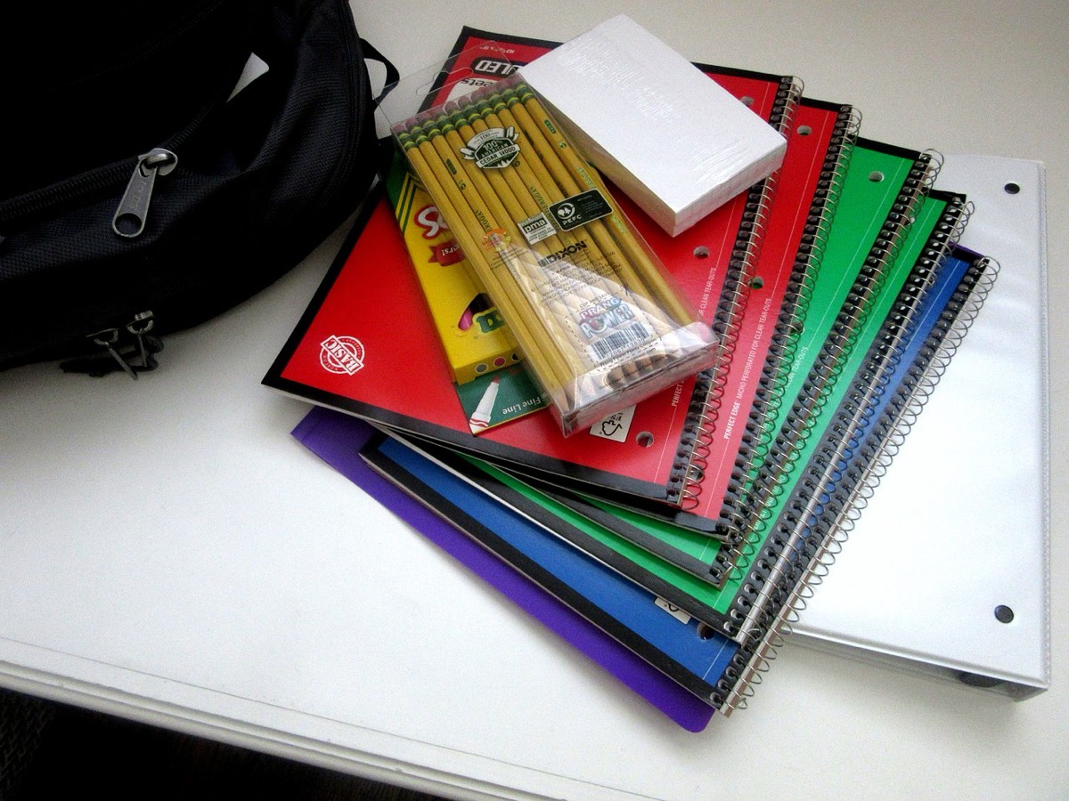 School supplies — spiral notebooks, folders, pencils and a backpack